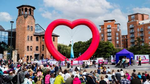 A dancer performing inside a large heart in Derby city centre
