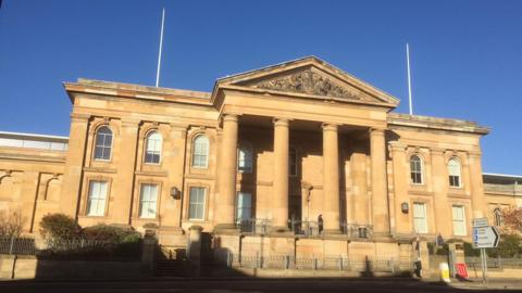 A court building with four large pillars at the front of the building