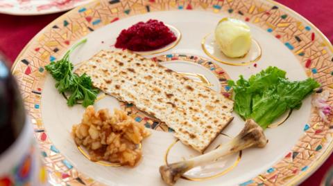 A Passover Seder plate with Charoset, Maror or Bitter Herbs, Karpas, Zeroah or Lamb Shank, Beitza or Roasted Egg, and Matzoh