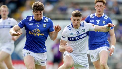 Cavan's Oisin Kiernan and Laois' Evan O’Carroll battle for possession