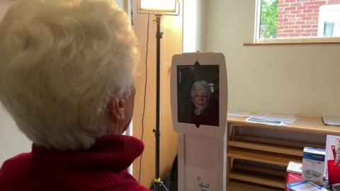 Woman having face scanned by tablet computer