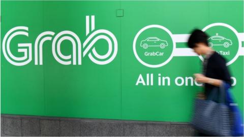 A woman walks past the Grab transport office in Singapore