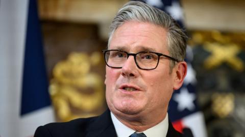Prime minister Keir Starmer wearing a suit and tie speaks during a press conference.
