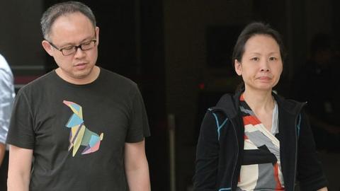 Trader Lim Choon Hong (L) and his wife, Chong Sui Foon (R), both 47, leave the state court in Singapore on March 23, 2016.