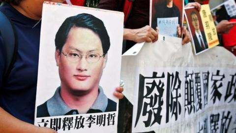 Pro-democracy protesters carry a photo of detained Taiwanese rights activist Lee Ming-Che (L) and other activists during a demonstration in Hong Kong, China 11 September 2017