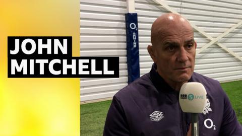 England head coach John Mitchell holding a BBC Radio 5 live microphone 