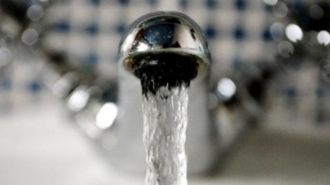 Water flows out of a metal tap