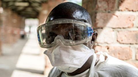 A health worker wears protective equipment as he looks on at Bikoro Hospital on 13 May