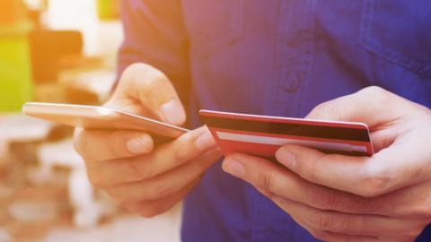 Man holding credit card and phone