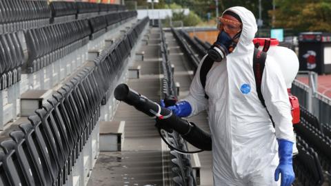 Technician disinfects seating area at Saracens