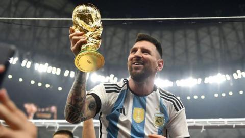 Argentina's Lionel Messi holding the World Cup trophy