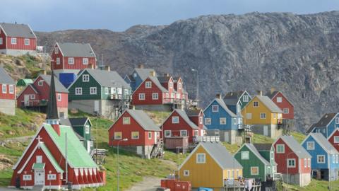 Colourful houses with triangle shaped roofs on a hillside in Greenland.