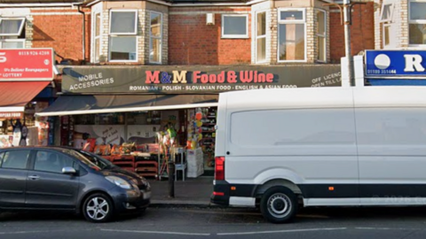 A Google Maps picture of M&M Food & Wine, a shop in a two-storey building with a white van parked and grey car outside it.