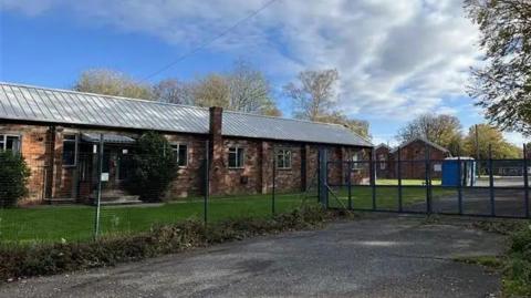 An exterior view of Crowborough Training Camp form outside the perimeter fence and locked gates. 