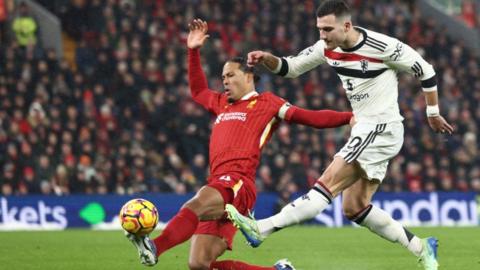 Liverpool defender Virgil van Dijk challenges for the ball with Manchester United defender Diogo Dalot