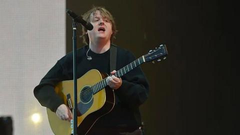 Lewis Capaldi playing the guitar at TRNSMT festival. 