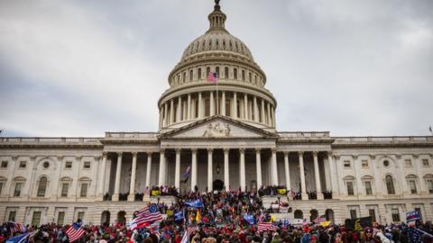 A large group of pro-Trump protesters stand on the East steps of the Capitol Building after storming its grounds on January 6, 2021