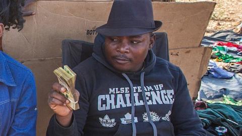 A gold buyer and gold digger trade in Malawian kwacha