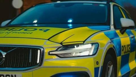 A Northumbria Police car. It is yellow and blue.