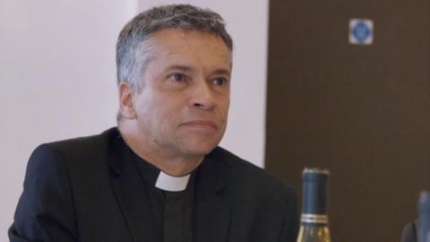 David Tudor, a vicar on Canvey Island, pictured taking part in a 91ȱ documentary in 2018. He appears in a black suit with a white dog collar, with greying hair.