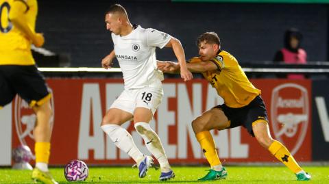 Luke Norris shields the ball for Boreham Wood in last season's National League Cup tie as Wolverhampton Wanderers' under-21 player Alfie Pond holds on to his jersey from behind