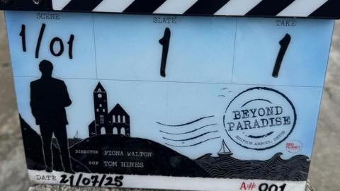 A clapperboard with an illustration of the coast and a tin mine, It says scene one of one, slate one and take one and gives the date as 21 July 2025. It says the director is Fiona Walton.