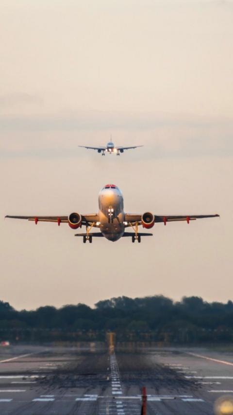 One plane takes off and another prepares to land at Gatwick.