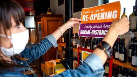 Woman in mask places sign on door