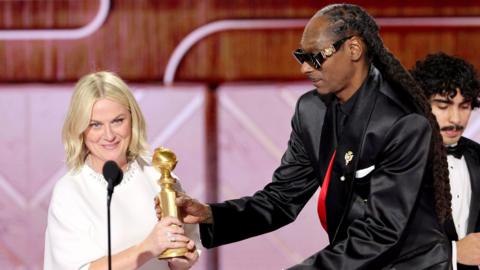 Amy Poehler, winner of the Best Podcast Award for "Good Hang With Amy Poehler," and Snoop Dogg speak onstage during the 83rd Annual Golden Globe Awards at The Beverly Hilton on January 11, 2026 in Beverly Hills, California.