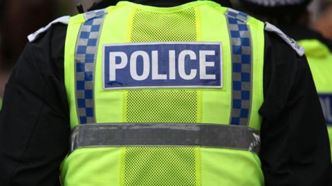 A generic image of a police officer wearing a hi viz vest with 'police' on the back.