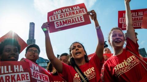 Supporters of Swedish PM hold signs