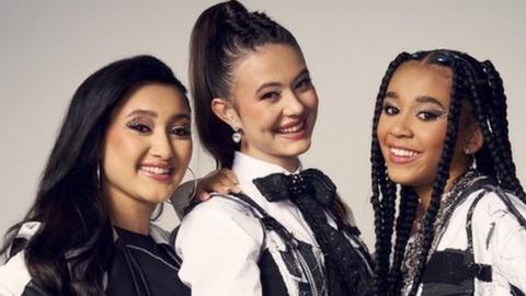 Yazmin, Maisie and Hayla stand in a line wearing black and white outfits