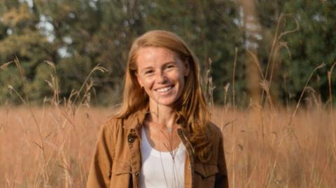 Rebecca Cooke, who is running in Wisconsin, standing in a field 