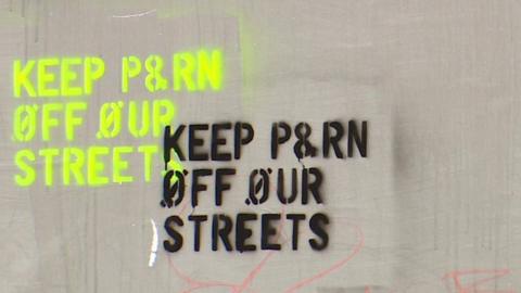 A close-up of part of the advert showing green and black spray-paint saying "keep porn off our streets".