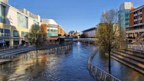 Flooding in front of the Reading Oracle. The pavement is submerged under water. 