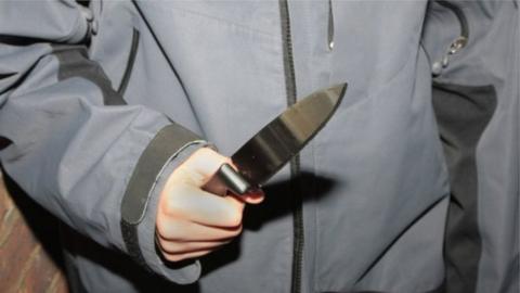 Young person holding a knife