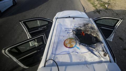 A destroyed car of the NGO World Central Kitchen sits along Al Rashid road