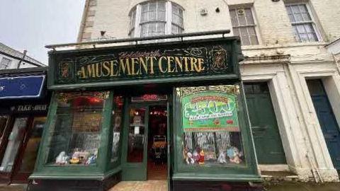 Facade of former amusement arcade which has a Victorian-style and is green in colour