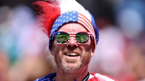 A fan of USA wearing a USA national flag hat and sunglasses 