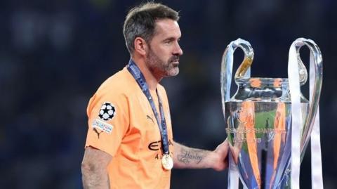 Scott Carson touches the Champions League trophy