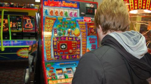 A person playing on a fruit machine