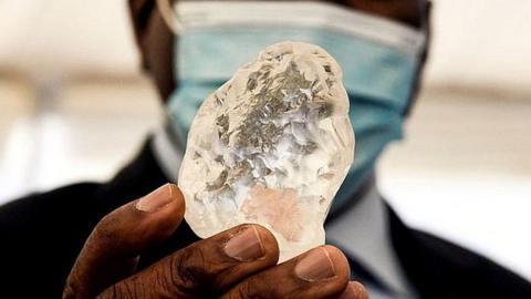 Botswana President Mokgweetsi Masisi holds the diamond in Gaborone, on June 16, 2021