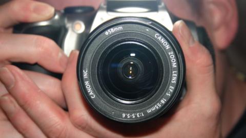 Stills camera being held