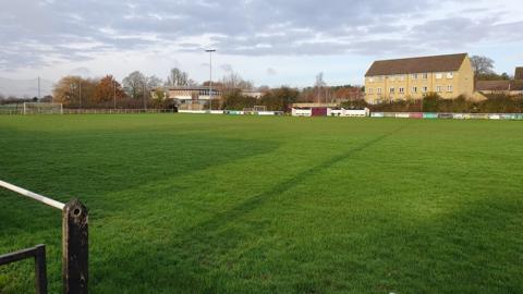 A green grass pitch surrounded by a residential area.