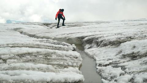 Man walks across a crack in the ice