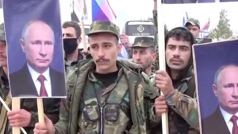 Syrian soldiers holding pictures of Vladimir Putin