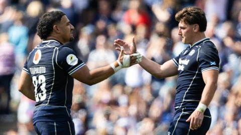 Sione Tuipulotu and Tom Jordan embrace