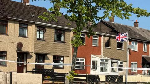 A row of terrace houses with tape across it