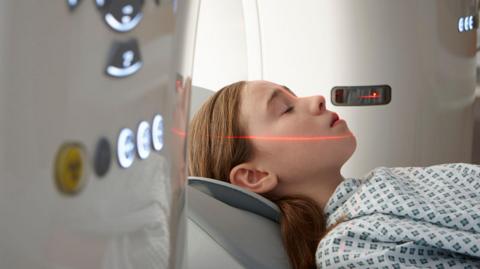 A girl entering a CT scanning machine