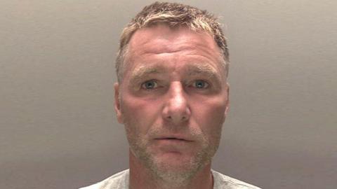 A police mugshot of Jordan Scott-Michael, who has light stubble and short, spiky dark blonde hair